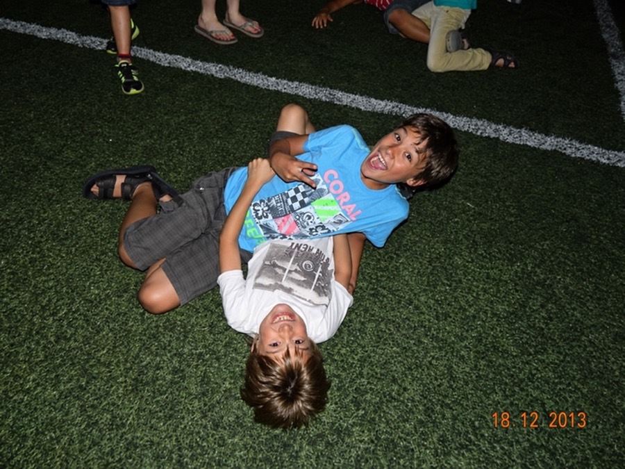 Andre y Joaquín de chicos, riéndose tirados en una cancha